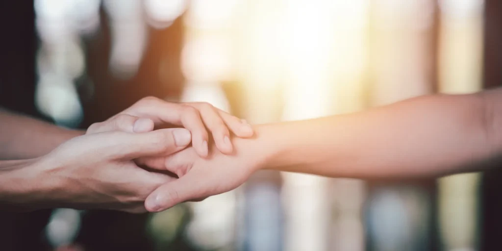Two hands gently touching, symbolizing emotional support during IVF